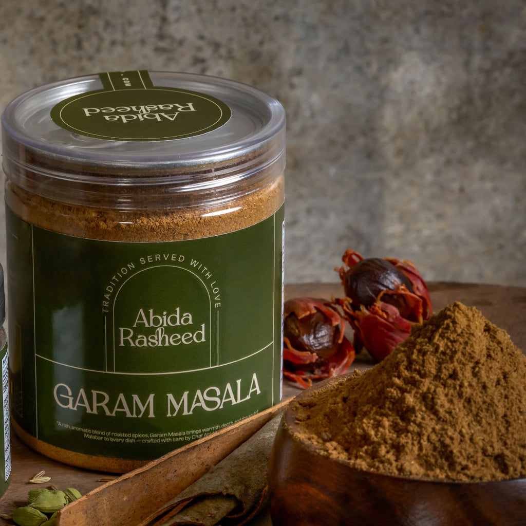 Jar of Abida Rasheed Garam Masala with spices on a wooden surface