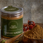 Jar of Abida Rasheed Garam Masala with spices on a wooden surface